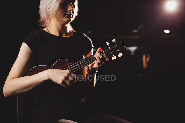 Mulher bonita tocando uma guitarra na escola de música — Fotografia de Stock