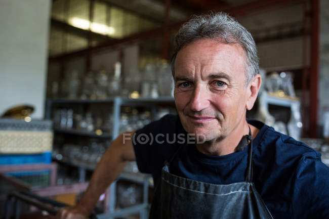 Ritratto di soffiatore di vetro sorridente alla fabbrica di soffiaggio del vetro — Foto stock
