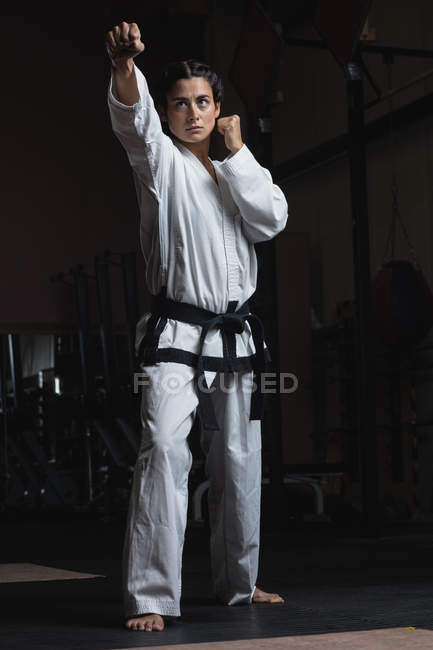 Giovane donna che pratica karate in palestra — Foto stock