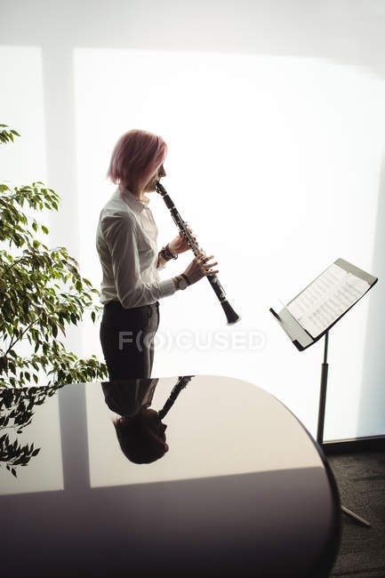 Увага жінка грає кларнет в музичній школі — стокове фото
