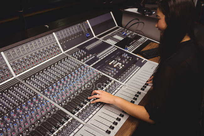Female student using sound mixer in a studio — Stock Photo