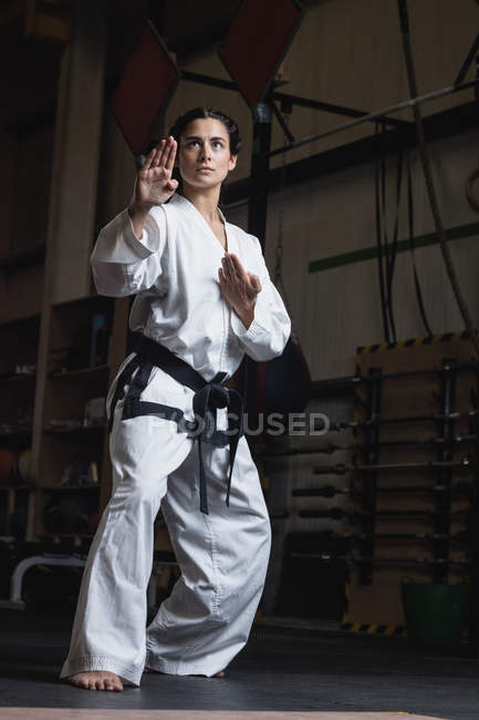 Vista a basso angolo della donna che pratica karate in palestra — Foto stock
