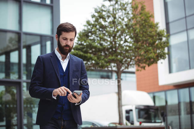 Empresario usando teléfono móvil fuera de la oficina - foto de stock