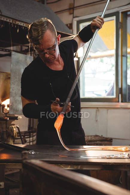 Souffleur de verre travaillant sur le verre fondu à l'usine de soufflage de verre — Photo de stock