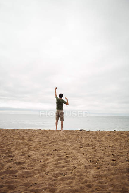 Вид ззаду чоловіка, що стоїть на пляжі — стокове фото