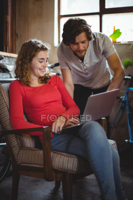 Casal usando laptop na loja de bicicletas — Fotografia de Stock