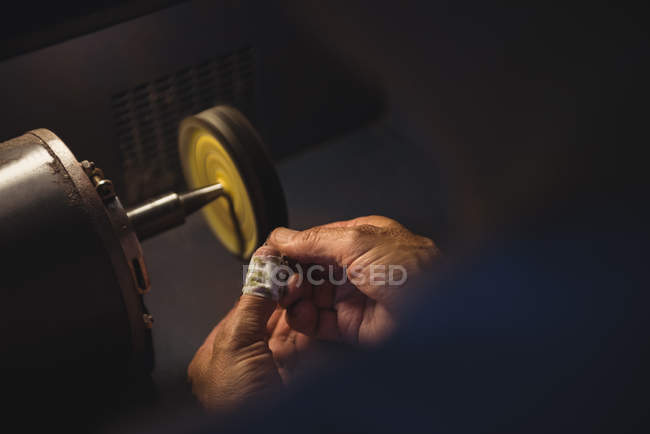 Mains d'artisan travaillant sur une machine en atelier — Photo de stock