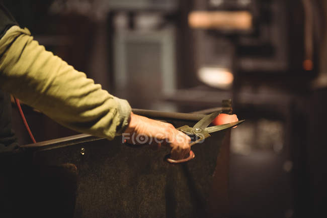 Glassblower working on molten glass at glassblowing factory — Stock Photo