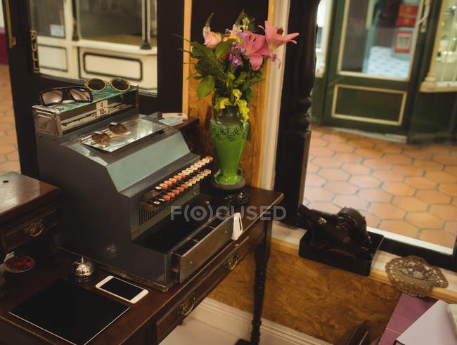 Старий друкарський верстат і ваза за лічильником в магазині — стокове фото