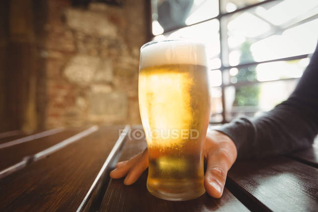 Nahaufnahme eines Mannes mit einem Glas Bier an der Bar — Stockfoto