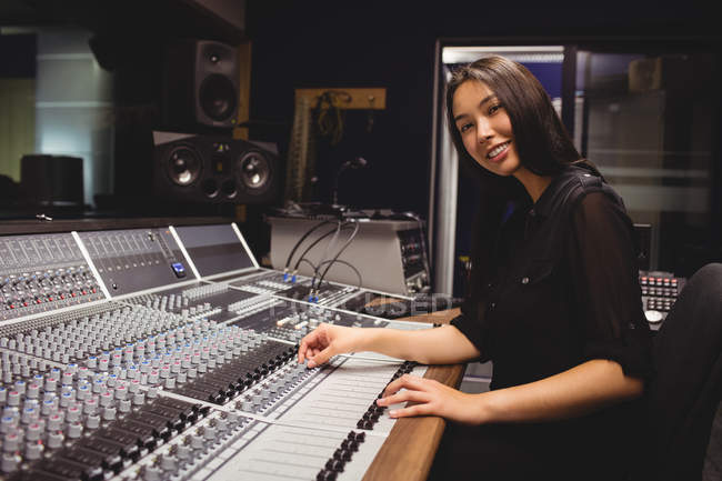 Female student using sound mixer in a studio — Stock Photo