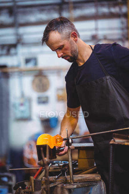 Soffiatore formando e modellando un vetro fuso presso la fabbrica di soffiaggio del vetro — Foto stock