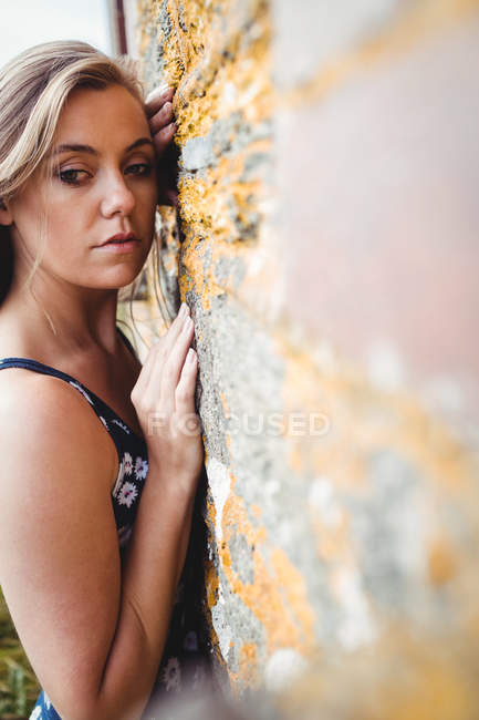 Mulher pensativo inclinado na parede em penhasco — Fotografia de Stock