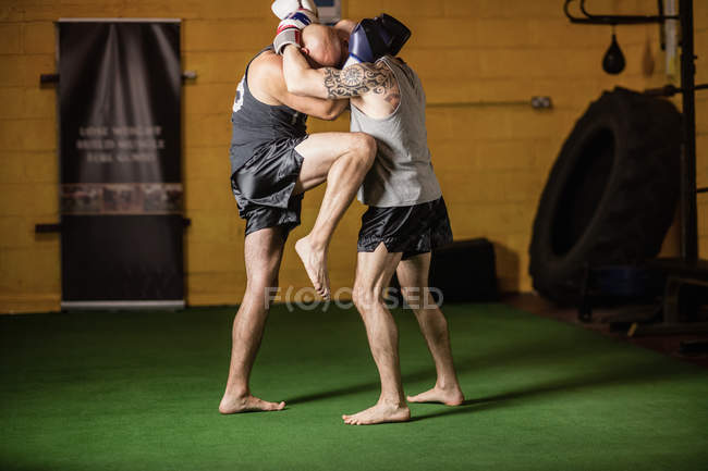 Vue latérale de deux boxeurs thaïlandais pratiquant dans la salle de gym — Photo de stock