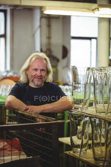 Retrato del soplador de vidrio sonriente en la fábrica de soplado de vidrio - foto de stock