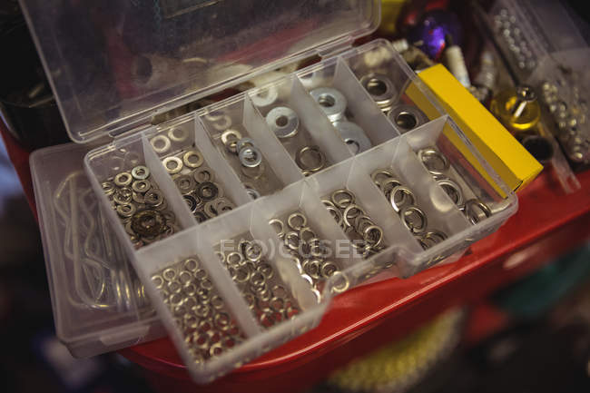 Крупный план различных винтовых крышек в коробке в мастерской — стоковое фото