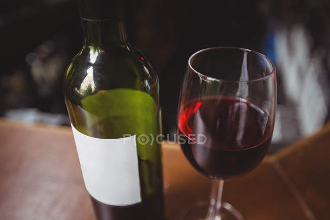 Primo piano di vetro con vino rosso sul bancone del bar al bar — Foto stock