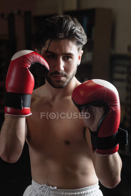 Retrato de Boxeador sin camisa practicando boxeo en gimnasio - foto de stock