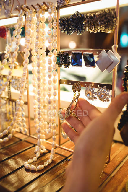 Hand of woman selecting jewellery in a antique jewellery shop — Stock Photo