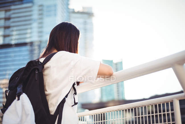 Frau lehnt sich an Geländer, während sie die Aussicht betrachtet — Stockfoto