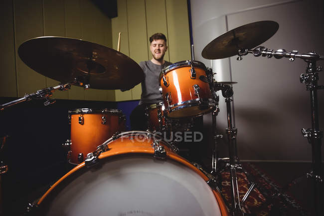 Male student playing drum set in a studio — Stock Photo