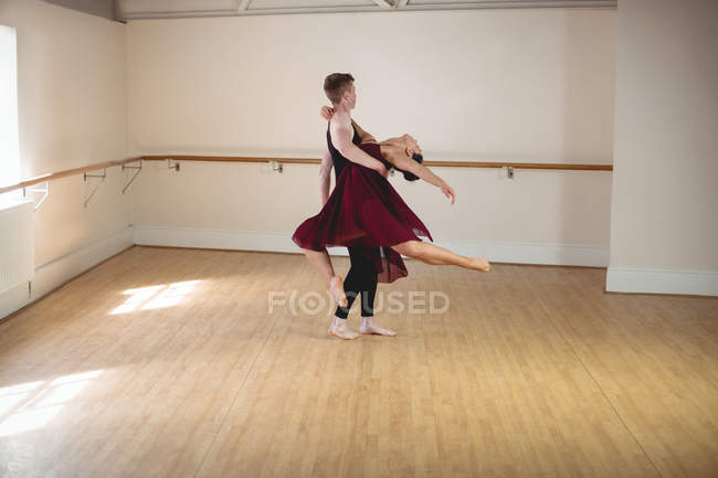 Parejas de ballet masculino y femenino bailando juntas en un estudio moderno - foto de stock