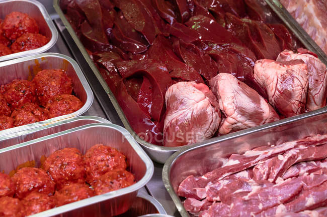 Variedade de carne marinada no balcão de exposição no açougue — Fotografia de Stock