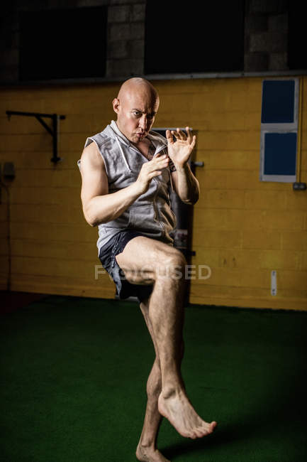 Guapo kick boxer boxeador practicando boxeo en el gimnasio - foto de stock