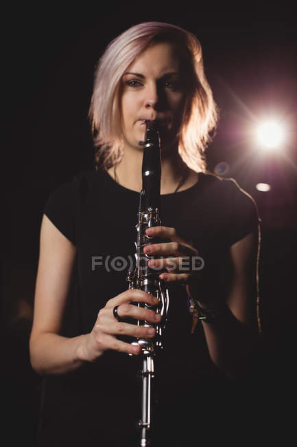 Étudiante jouant de la clarinette dans un studio — Photo de stock