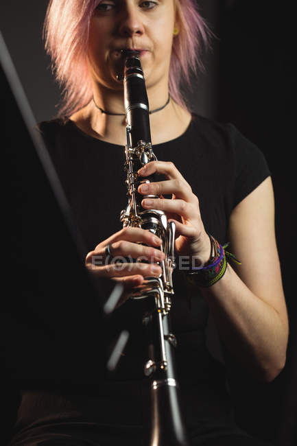 Mulher bonita tocando um clarinete na escola de música — Fotografia de Stock