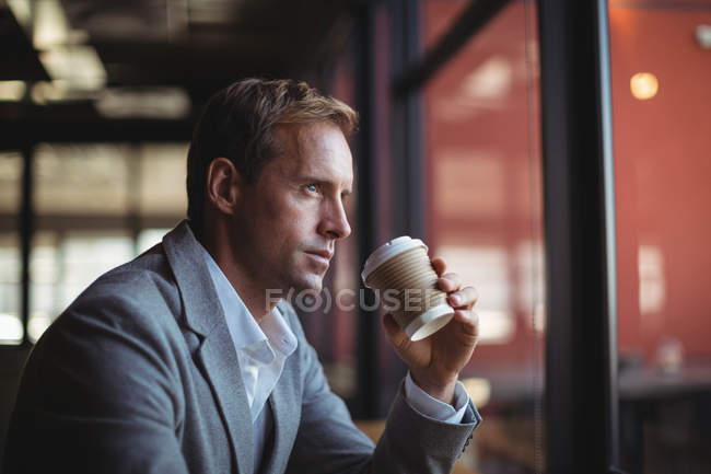 Uomo d'affari premuroso che prende un caffè nel caffè — Foto stock