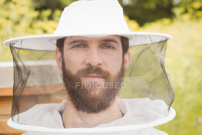 Retrato del apicultor que trabaja en el campo - foto de stock