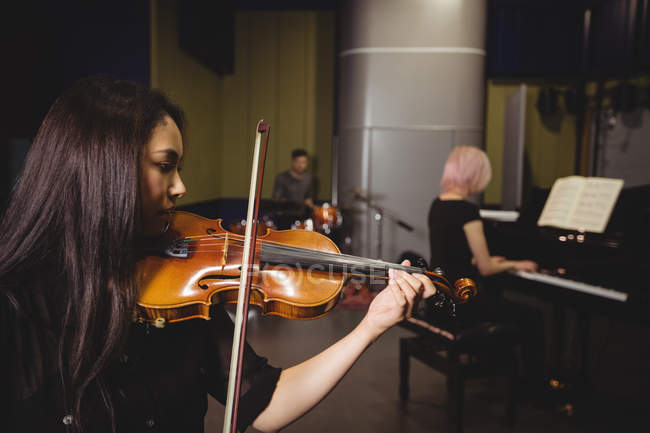 Deux étudiantes jouant du violon et du piano dans un studio — Photo de stock