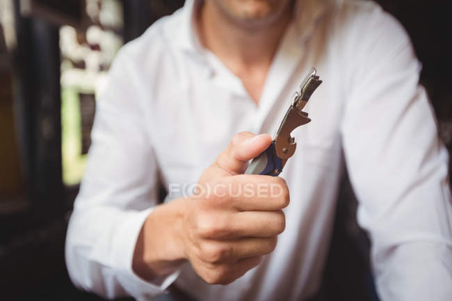 Close-up of bartender a bottle opener at bar counter — Stock Photo