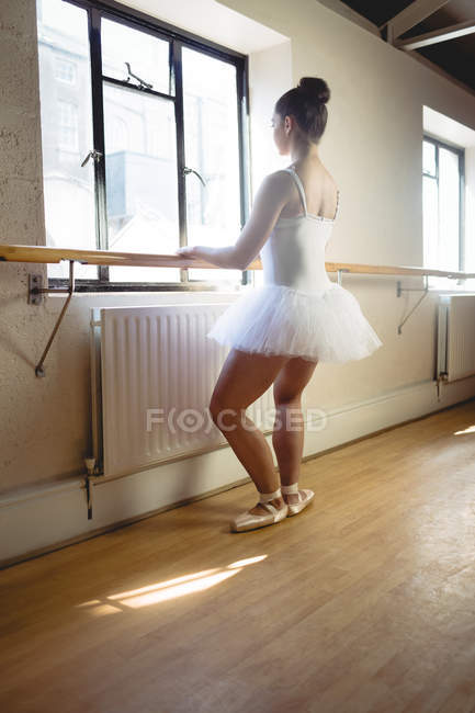 Ballerina übt Balletttanz an der Barre im Studio — Stockfoto
