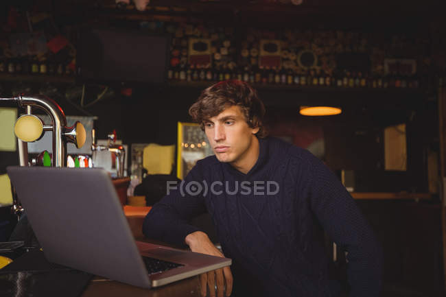Человек, использующий ноутбук в баре — стоковое фото