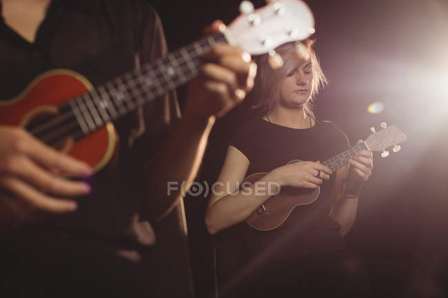Hermosas mujeres tocando una guitarra en la escuela de música - foto de stock