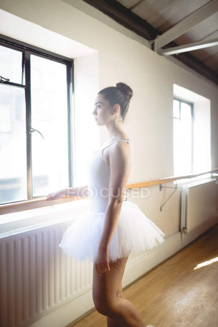 Вид збоку балерина холдингу бар в студії — стокове фото