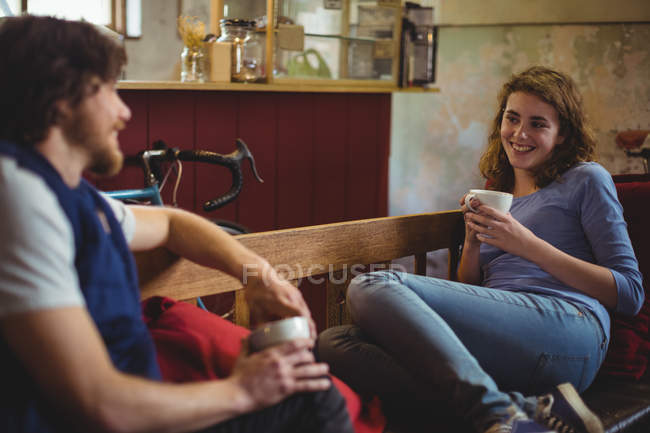 Mechanics interacting with each other while having coffee in workshop — Stock Photo