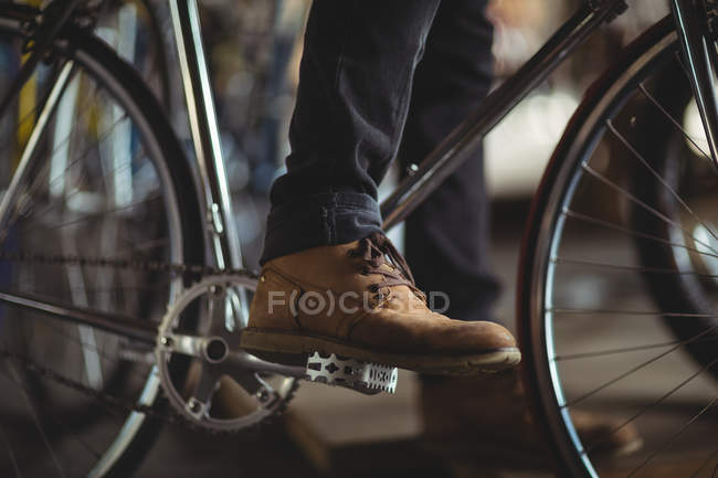 Mechanic trying bicycle in workshop — Stock Photo