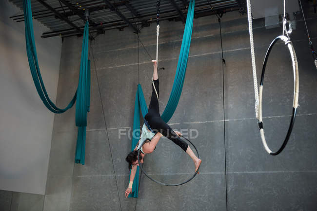 Gimnasta realizando gimnasia en el aro en el gimnasio - foto de stock