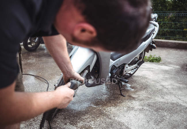 Motorcycle washing with pressure washer at workshop — Stock Photo