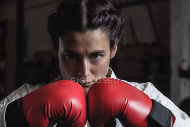 Портрет уверенной женщины в боксёрских перчатках в фитнес-студии — стоковое фото