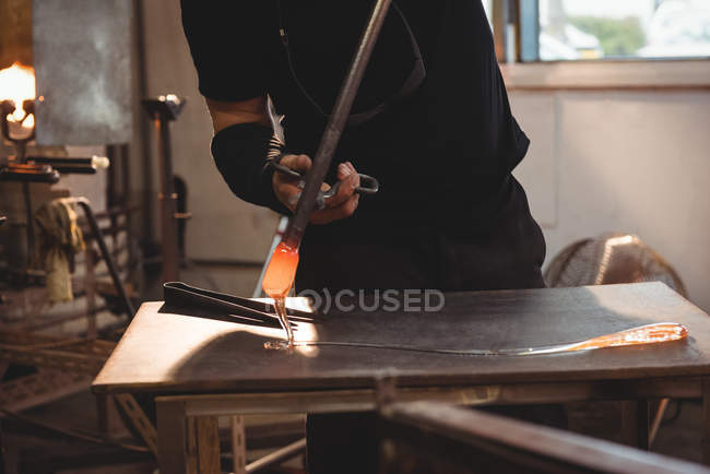 Immagine ritagliata del soffiatore di vetro che lavora sul vetro fuso alla fabbrica di soffiaggio del vetro — Foto stock