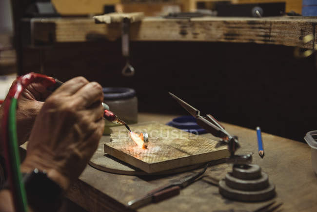 Mani di artigiana utilizzando soffiare torcia in officina — Foto stock