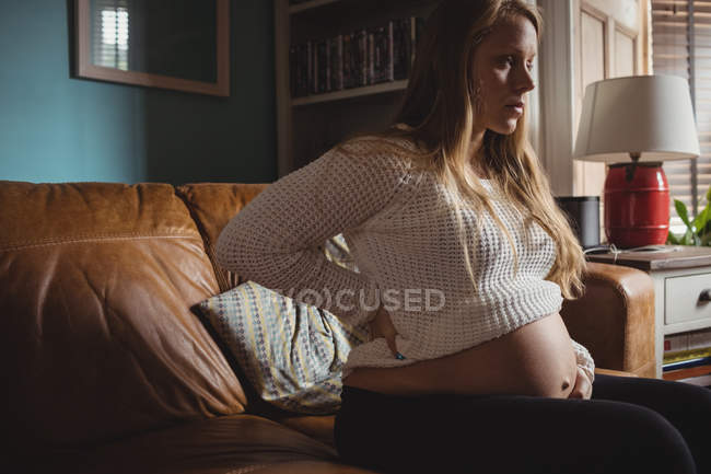 Приваблива вагітна жінка розслабляється у вітальні вдома — стокове фото