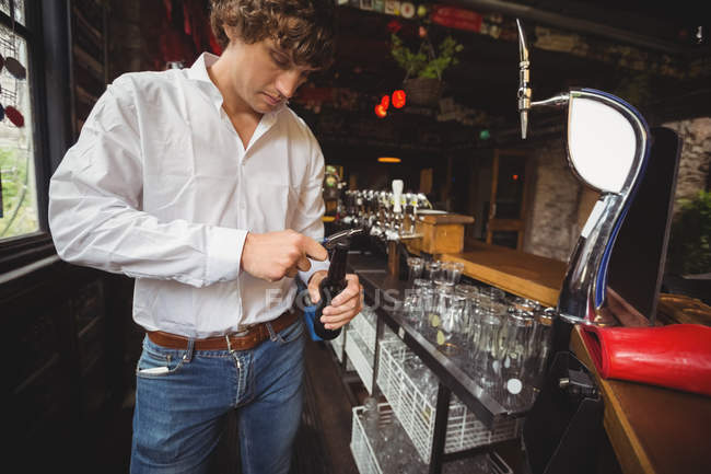 Barkeeper öffnet Bierflasche am Tresen — Stockfoto