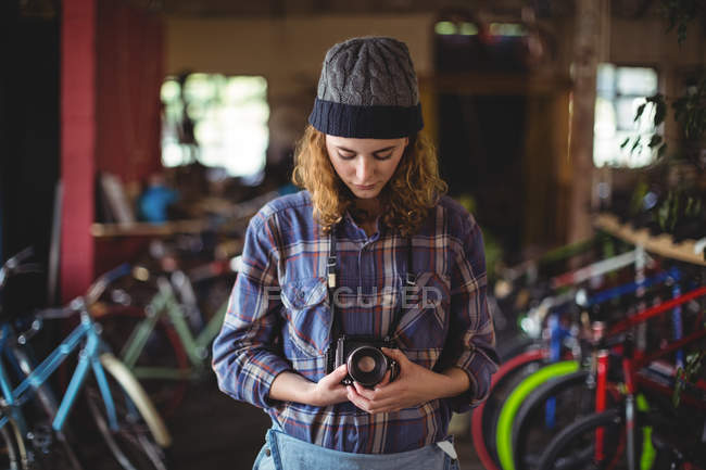 Frau justiert Oldtimer-Kamera in Fahrradladen — Stockfoto