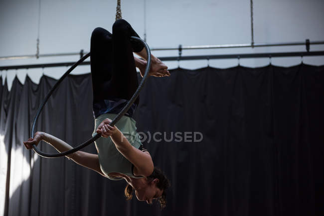 Young woman performing gymnastics on hoop in fitness studio — Stock Photo
