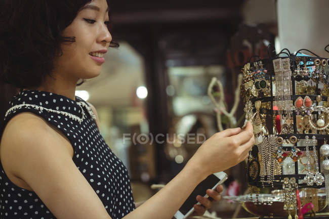 Femme élégante sélectionnant un bijoutier dans un magasin de bijoux d'antiquité — Photo de stock